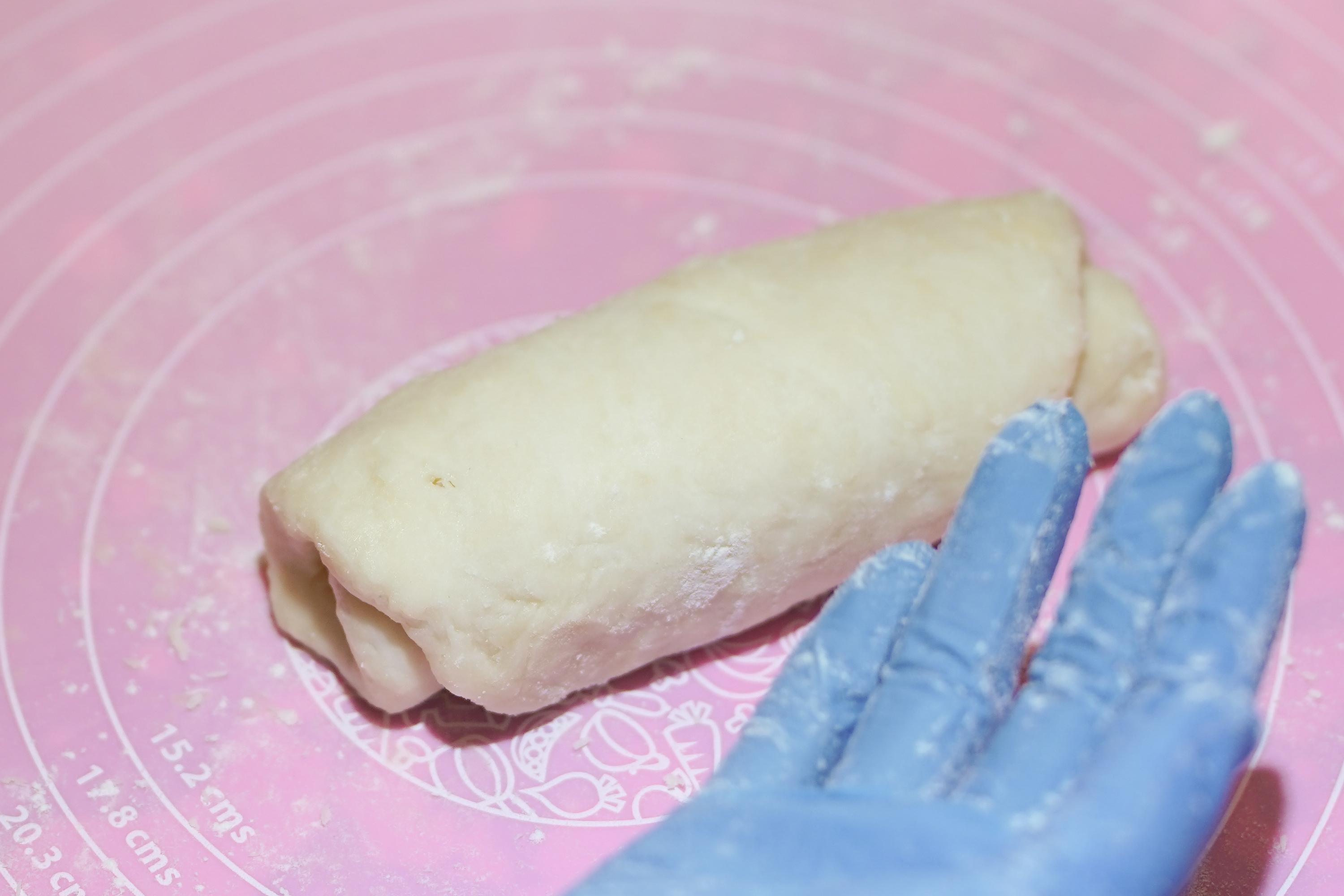 用水皮包住油酥皮搓圓,壓平後再捲成條狀,重覆兩次。