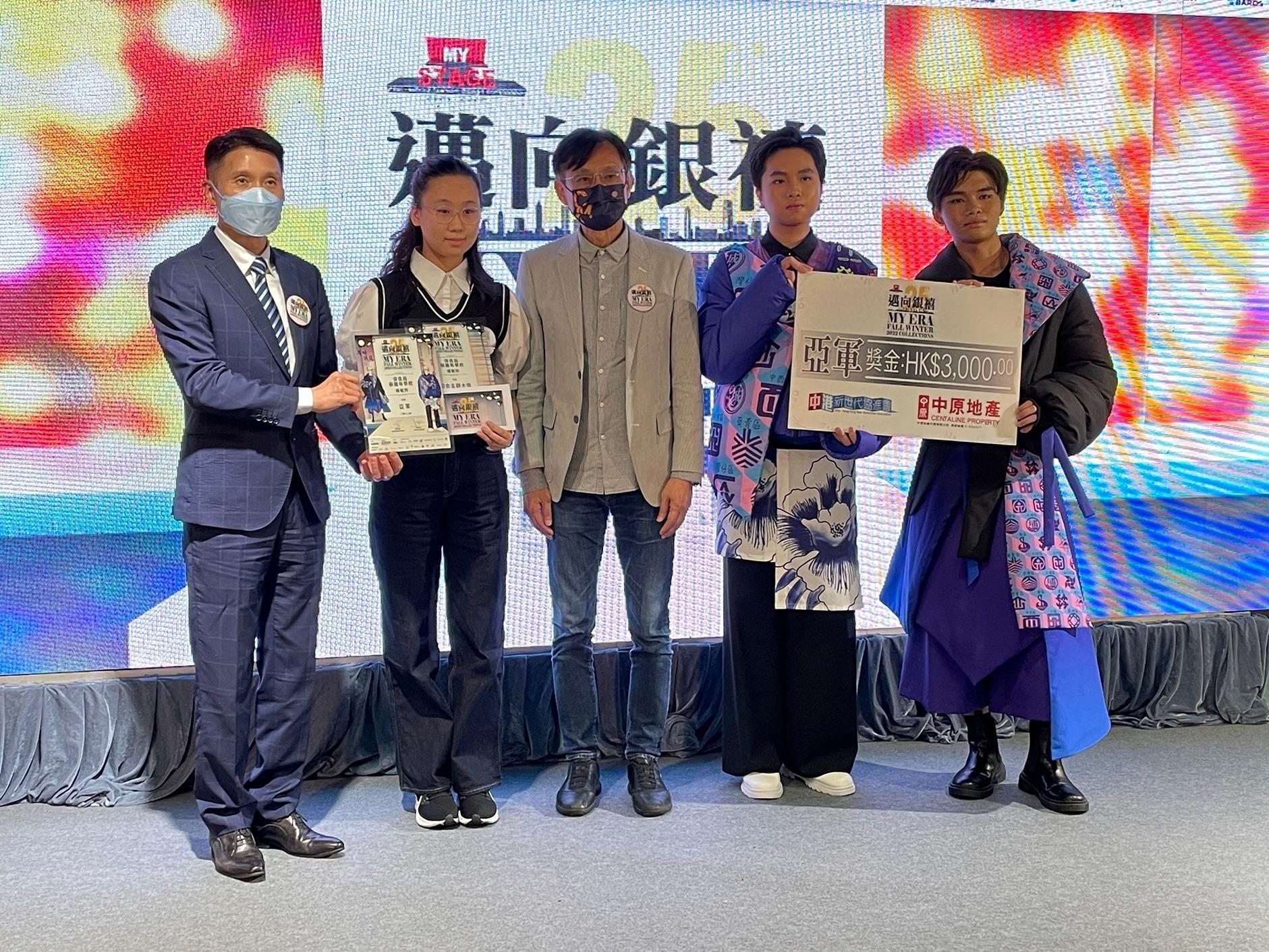 保良局蔡繼有學校的楊敏羚獲亞軍及切合主題大獎,設計靈感來源於人工智能和霓虹燈。系列融合「過去」和「未來」,有別於一般的冬季夾棉外套,服裝的剪裁採用充滿未來時代感,再配上充滿香港特色的18區標誌、色彩繽紛的麻雀繡花和手繪陶瓷花紋,突顯香港高速發展的同時,也不忘保留傳統工藝特色的重要性。