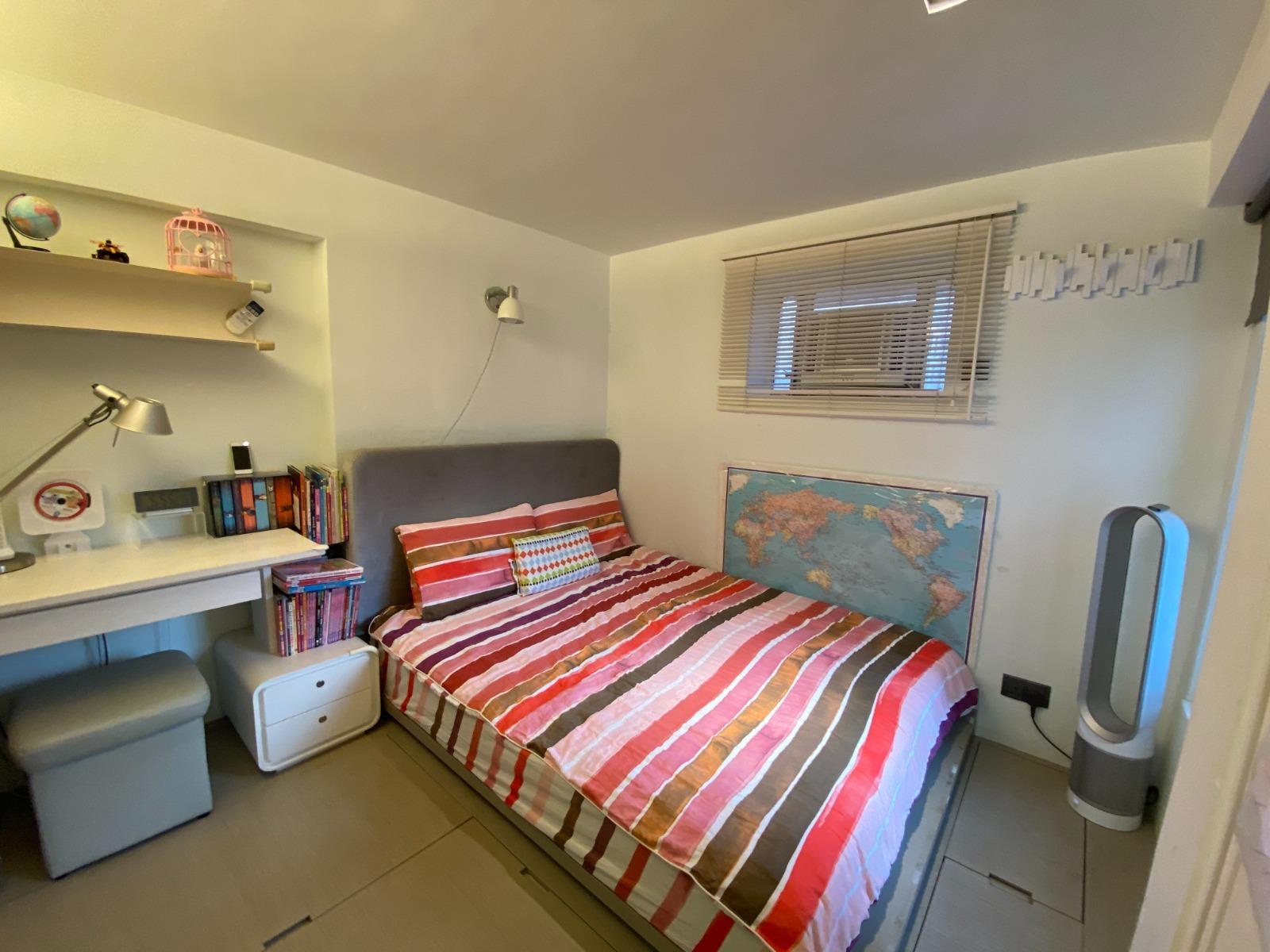 主人套房設有地台,並有特別訂製的梳裝枱和書櫃,裝修和傢俱均簡約實用。