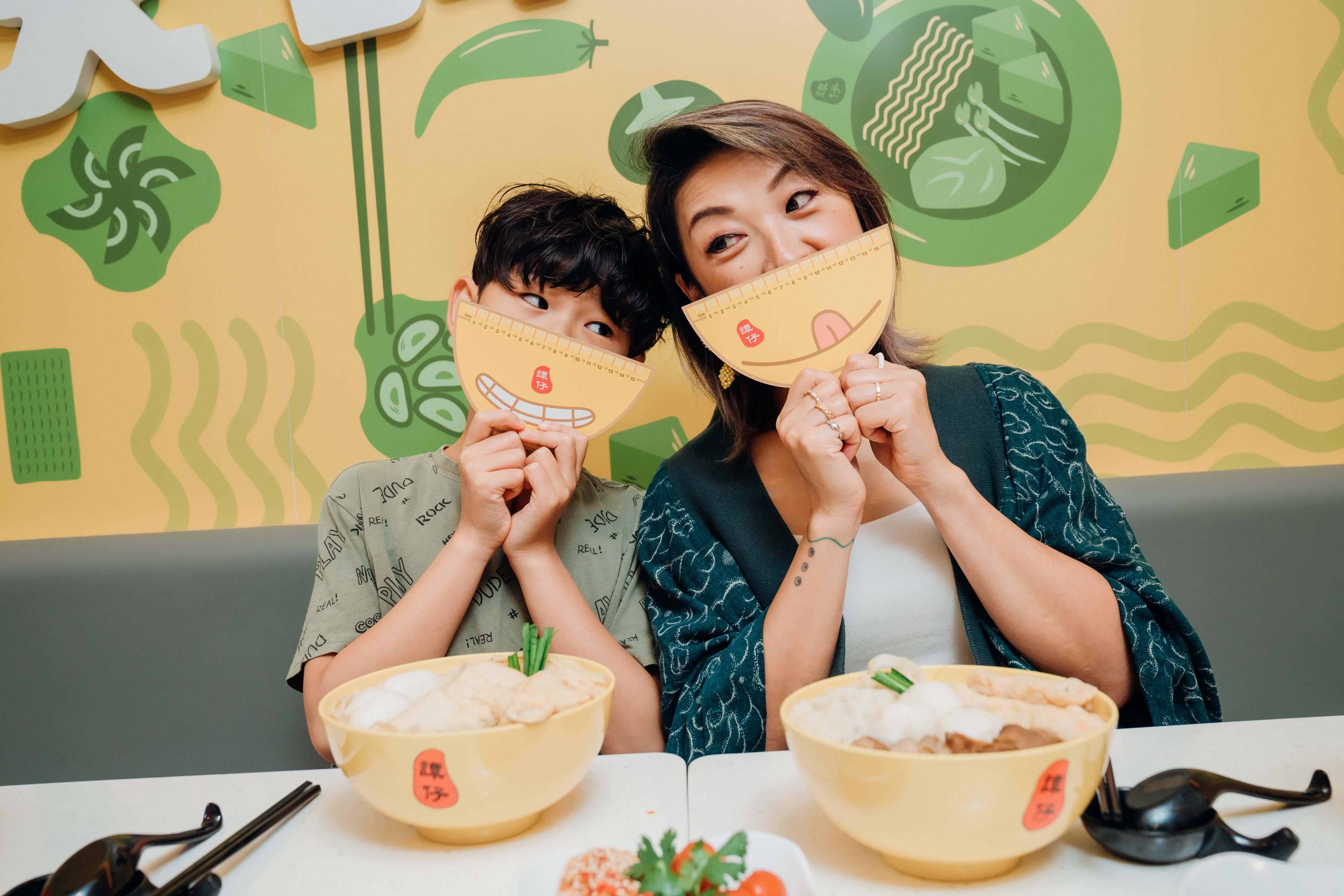 朱薰兩母子齊齊以寛面尺量度面部閣度。