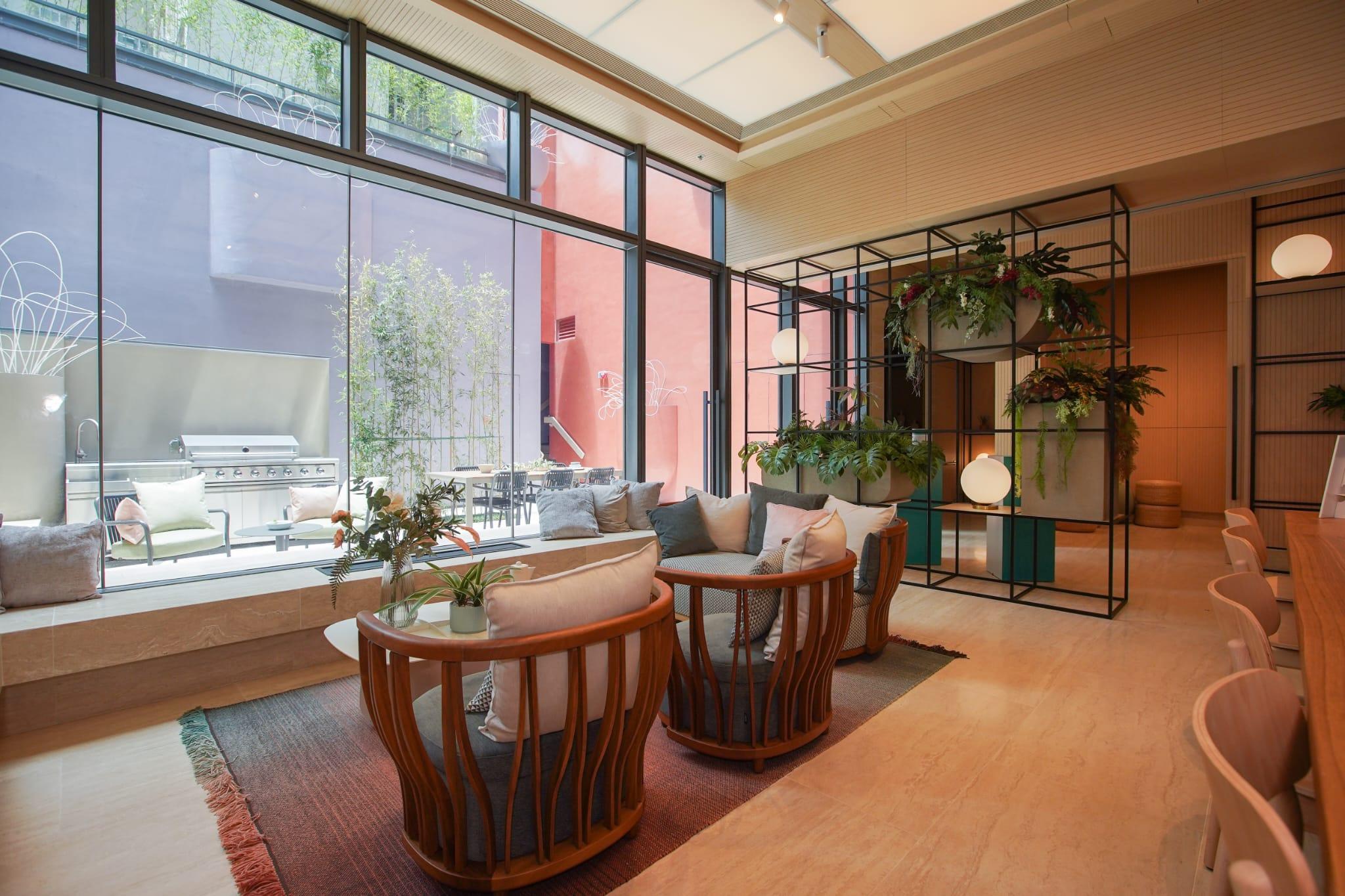 位於1樓的住客會所以木材裝飾設計而成,配合玻璃外牆,營造通透開揚的空間感。(李睿哲攝)