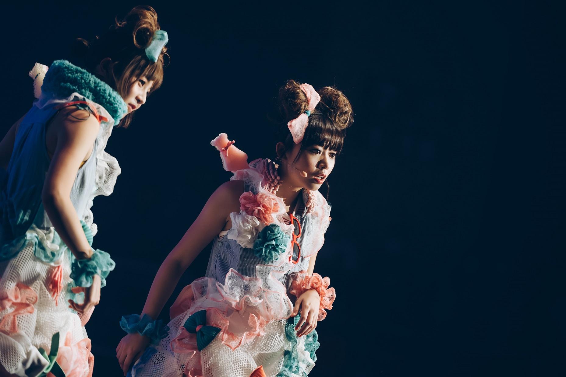 阿冰(左)和童童在《發達大計》拍賣會唱跳新歌《有錢未》。