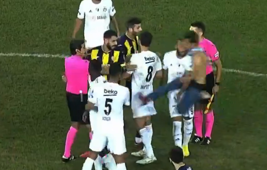 一名球迷衝入球場飛踢比錫達斯球員的背部。(影片截圖)