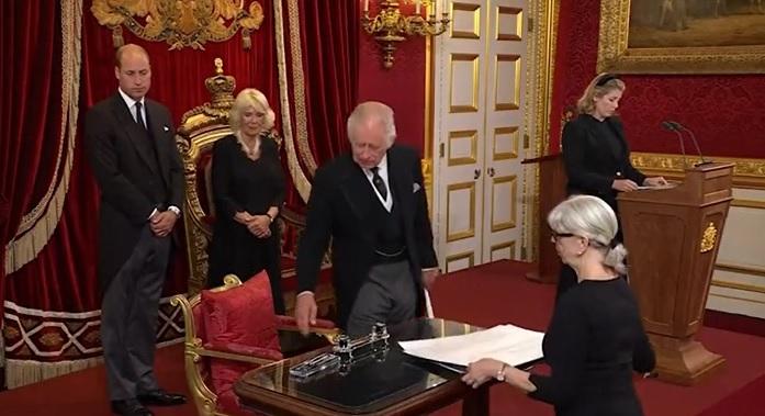 簽登基文件時,查理斯手指指,示意待從移走桌上的文具。(互聯網)