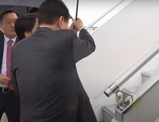 尹錫悅接過夫人手上雨傘後,只顧著為自己擋雨。(互聯網)