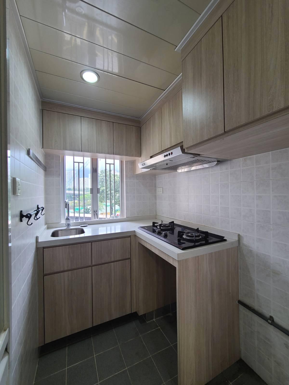 以木色為主調的廚房,面積不細小,一系列廚櫃美觀又新淨。