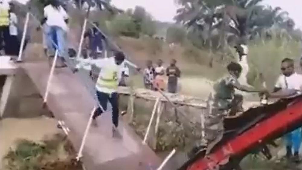 橋上的官員差點摔落至溪流中,情境非常狼狽。(Twitter)