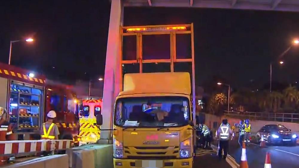 涉事Tesla懷疑失控撞向停泊於上址的箭嘴車,3名工人受傷。(電視截圖)