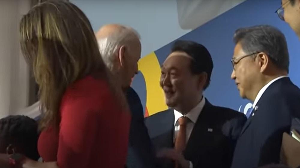 尹錫悅在場合中與拜登合照,之後有握手交談,更將輕拍拜的手。(YouTube)