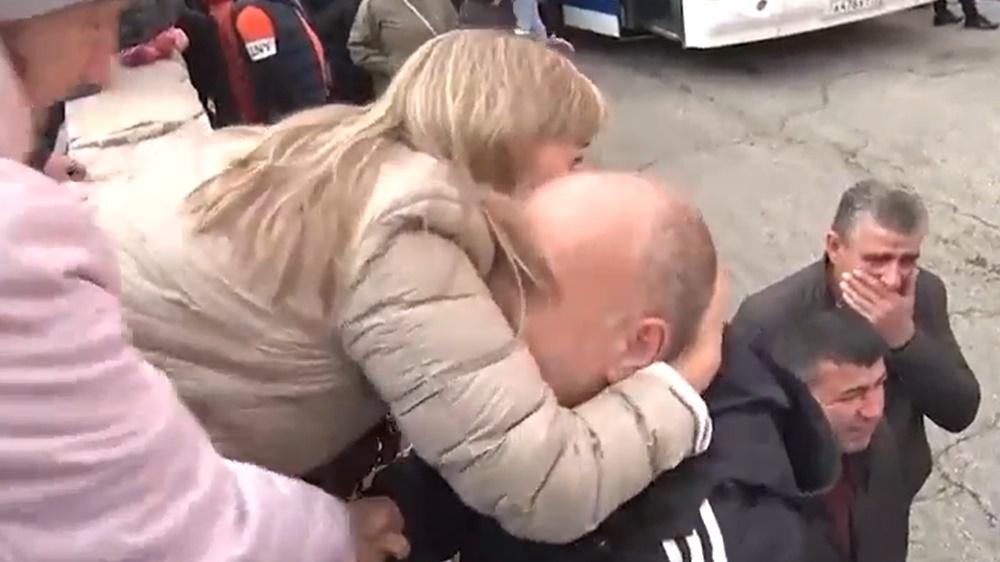 在Yakutia地區,顯示近百名俄羅斯人圍繞著幾架巴士,要與正在排隊上車的數十名男子含淚道別。(Twitter)