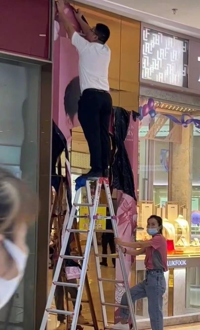 工作人員拆除李易峰的代言海報。(互聯網)