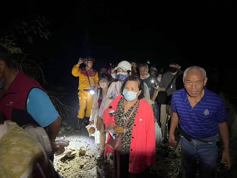 花蓮赤科山被困遊客在救援人員引領下,攀過落石前往安全地點。(互聯網)