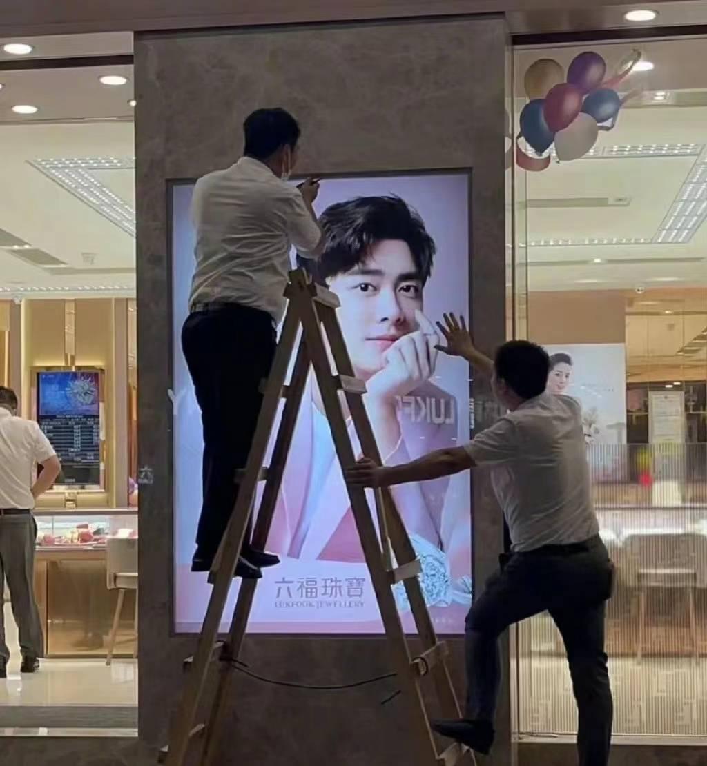 工作人員拆除李易峰的代言海報。(互聯網)