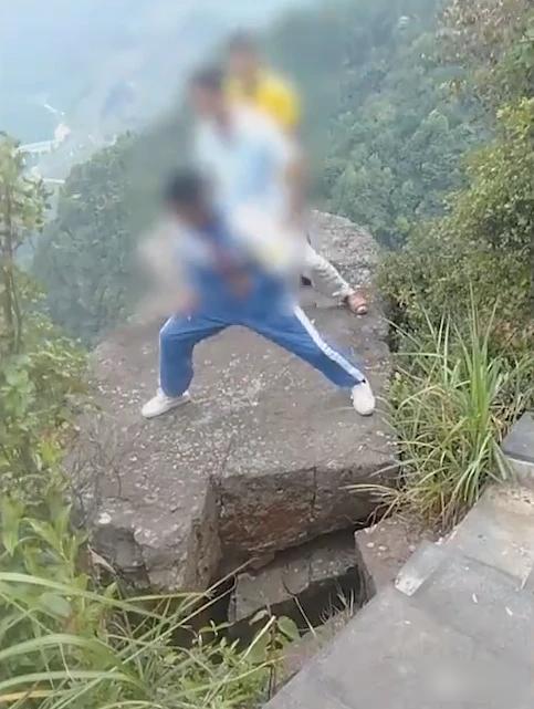 原先有3人在懸崖邊一塊鬆動巨石上用力搖晃。(互聯網)