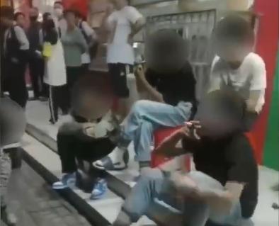 面對老人下跪,涉事學生坐在台階上吸煙。(互聯網)