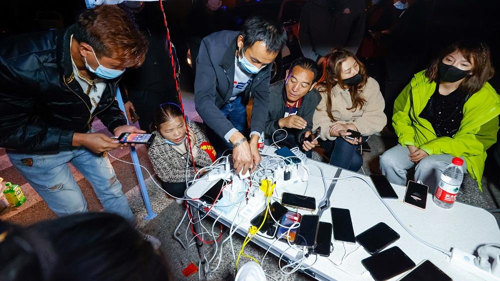 在瀘定縣磨西鎮受災人士臨時安置點,民眾在中國電信便民服務點為手機充電。(新華社)