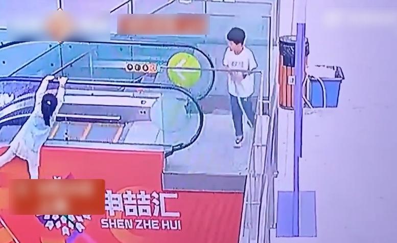女童掛在扶手電梯外,一路被帶上2樓。(互聯網)