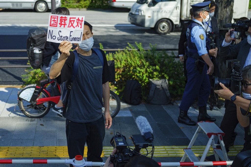 有民眾展示反對國葬標語。(美聯社)