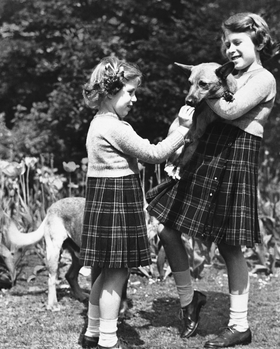 女王小時候(右)已喜歡狗狗,身旁的是女王妹妹瑪嘉烈公主。(美聯社)
