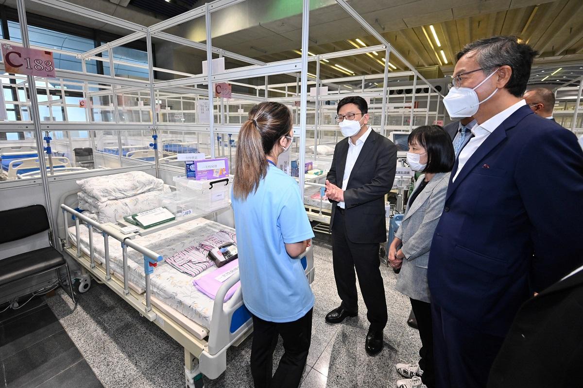 孫玉菡(左二)和社會福利署長李佩詩(左三)、基督教靈實協會行政總裁林正財(左四),聽取照顧專隊人員簡介檢疫床位的設備。(政府新聞處)