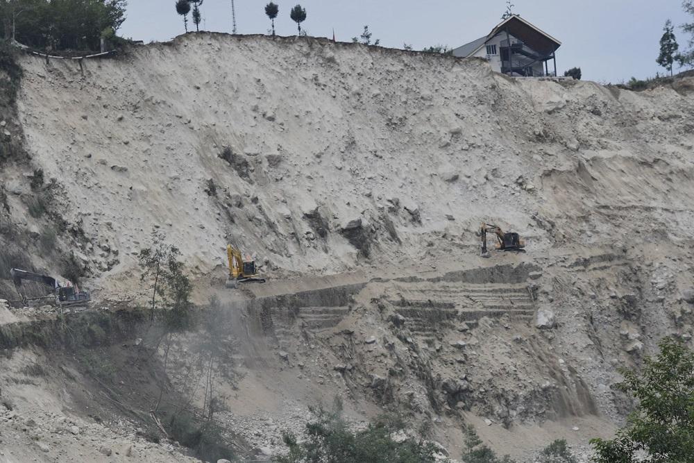 2部挖泥機全力清理磨西鎮通往海螺溝景區的唯一道路。(互聯網)