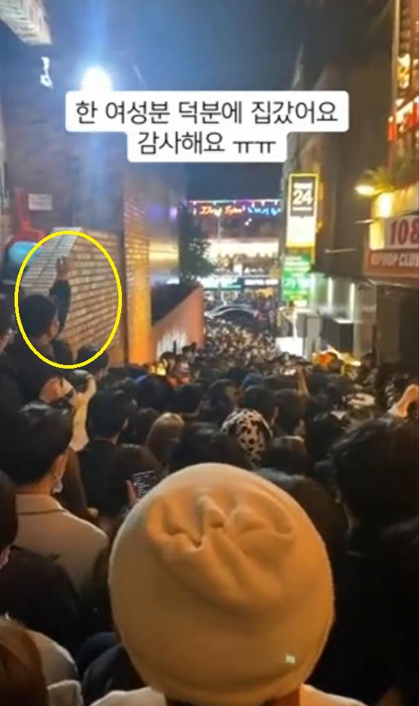 女子揚手,不停叫人群往下走。(互聯網)