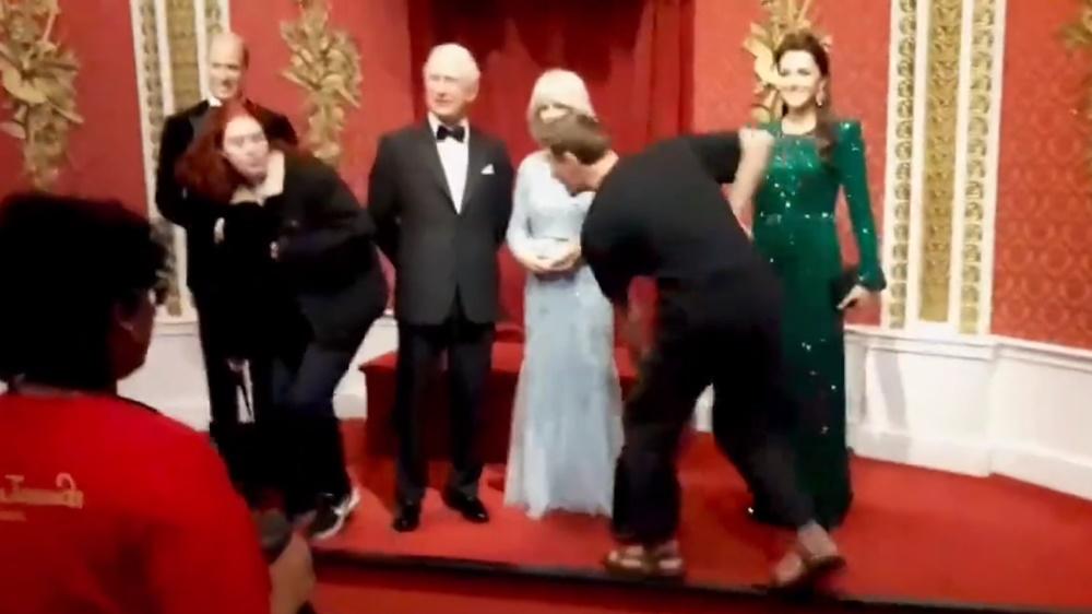 2名身穿黑衣的男女在杜莎夫人蠟像館的國王查理斯三世的蠟像前高叫口號。(Twitter)