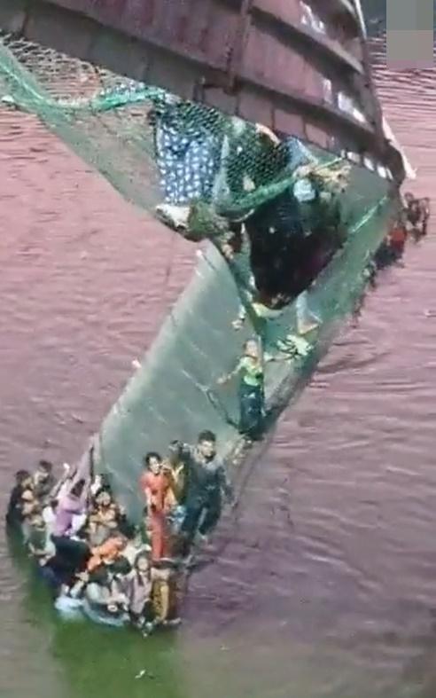 大批民眾在橋塌後墜河,不少人掙扎抓緊橋的纜索等待救援。(Twitter)