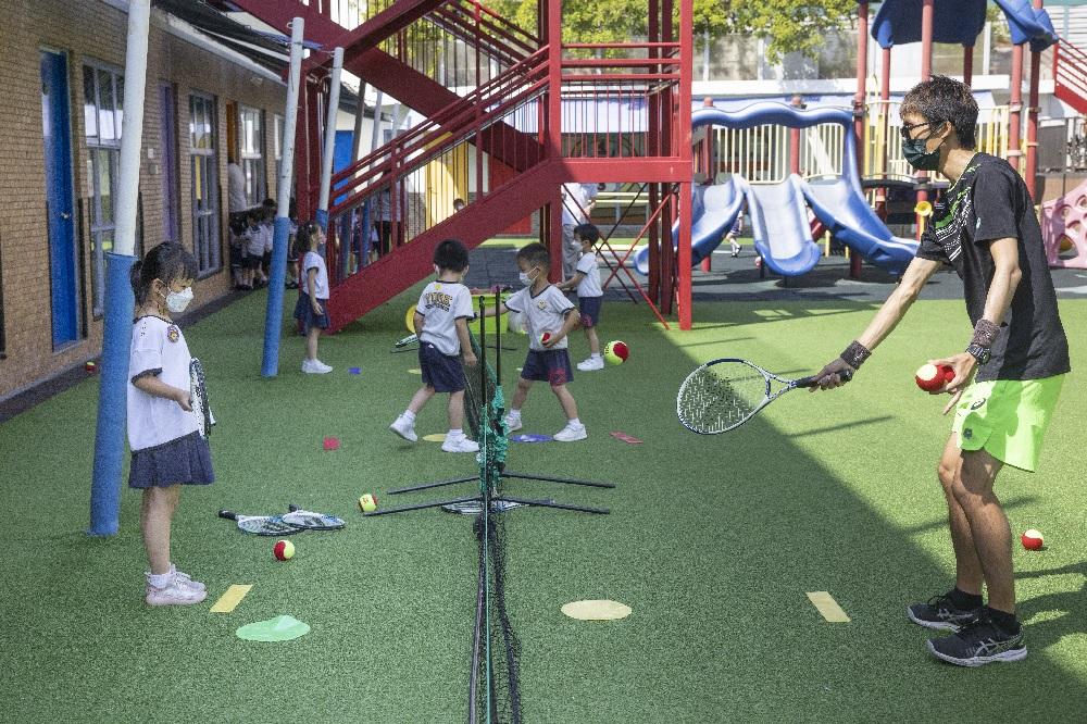 專業的網球教練利用海綿球教導學生打網球。