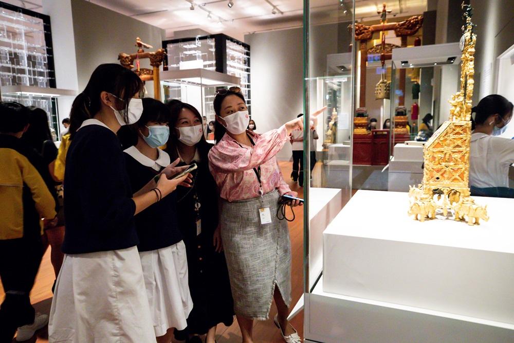 政青常務副主席兼「青年穿越故宮之旅」項目聯合發起人張瑞祺(右)與參觀香港故宮的中學生一同欣賞展館內的珍貴文物。(政青圖片)