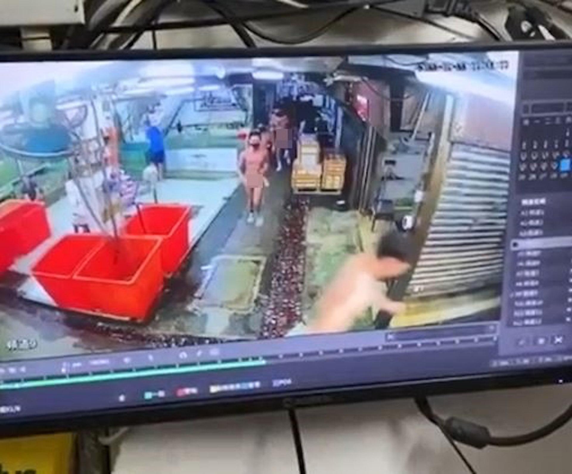 另一段影片,該群裸男在小巷中穿插,期間他們一度經過有職員正在工作的鋪頭。(網上圖片)