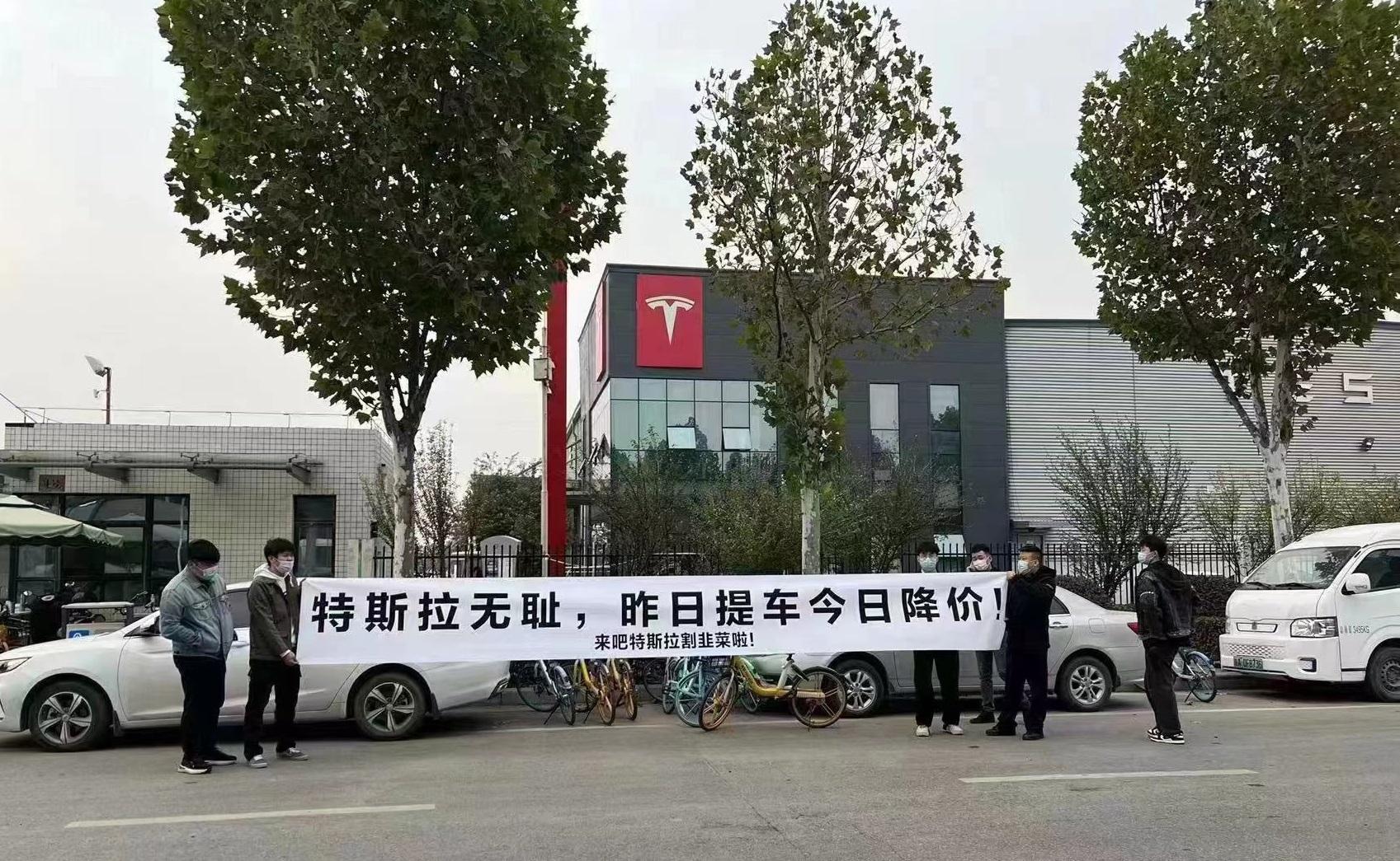 網上流傳,有車主到Tesla門市外拉橫額抗議減價。(互聯網)