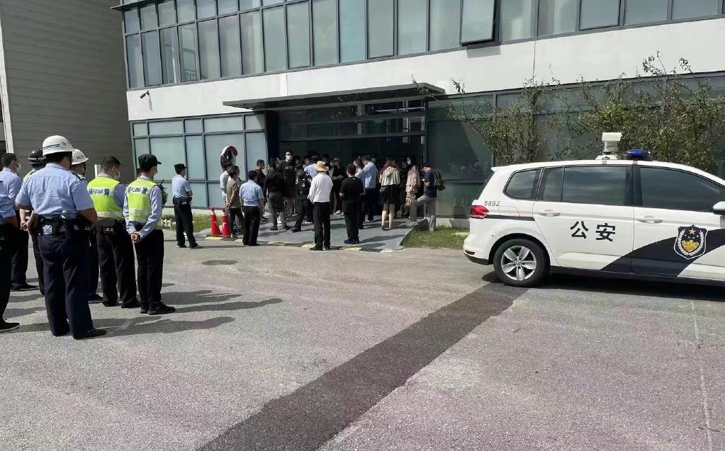 網上流傳,疑似有一批車主去到Tesla辦公大樓就減價「維權」,警方在旁戒備。(互聯網)