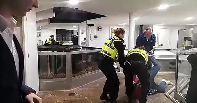 艾登堡用餐時被示威者滋擾,警員把示威者拉出餐廳。(互聯網)