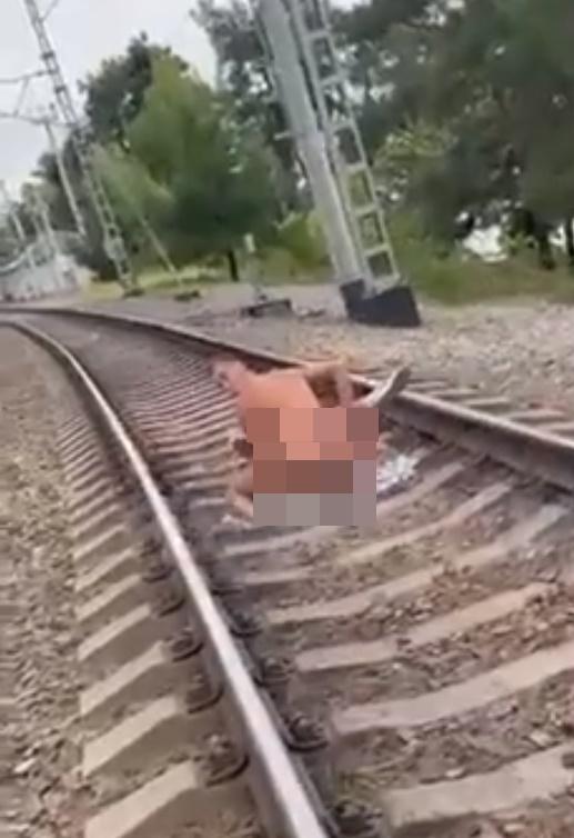 男子隨後與躺在鐵軌上的半裸女子穿回衣服起身準備離開。(Twitter)