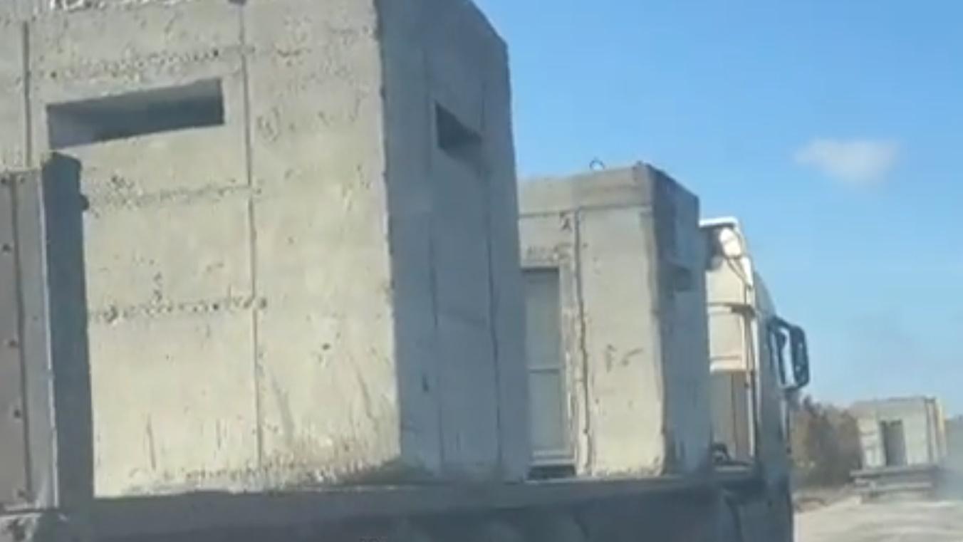 在俄軍撤退消息傳出的同時,網上亦有片段顯示,有多架卡車運載大型防禦混凝土設施到當地。(Twitter)