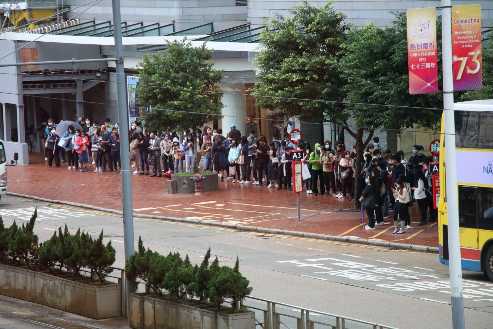 天文台決定在下午1時40分或以前改掛八號風球,不少市民提早回家,巴士站大排長龍。(林俊源攝)
