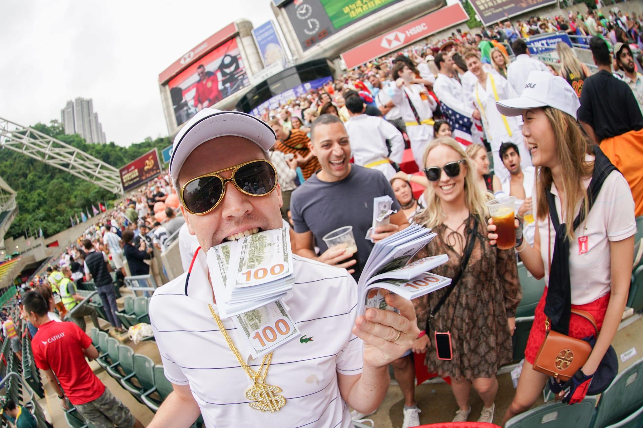 有球迷口咬「紙幣」,狀甚興奮。(李睿哲攝)