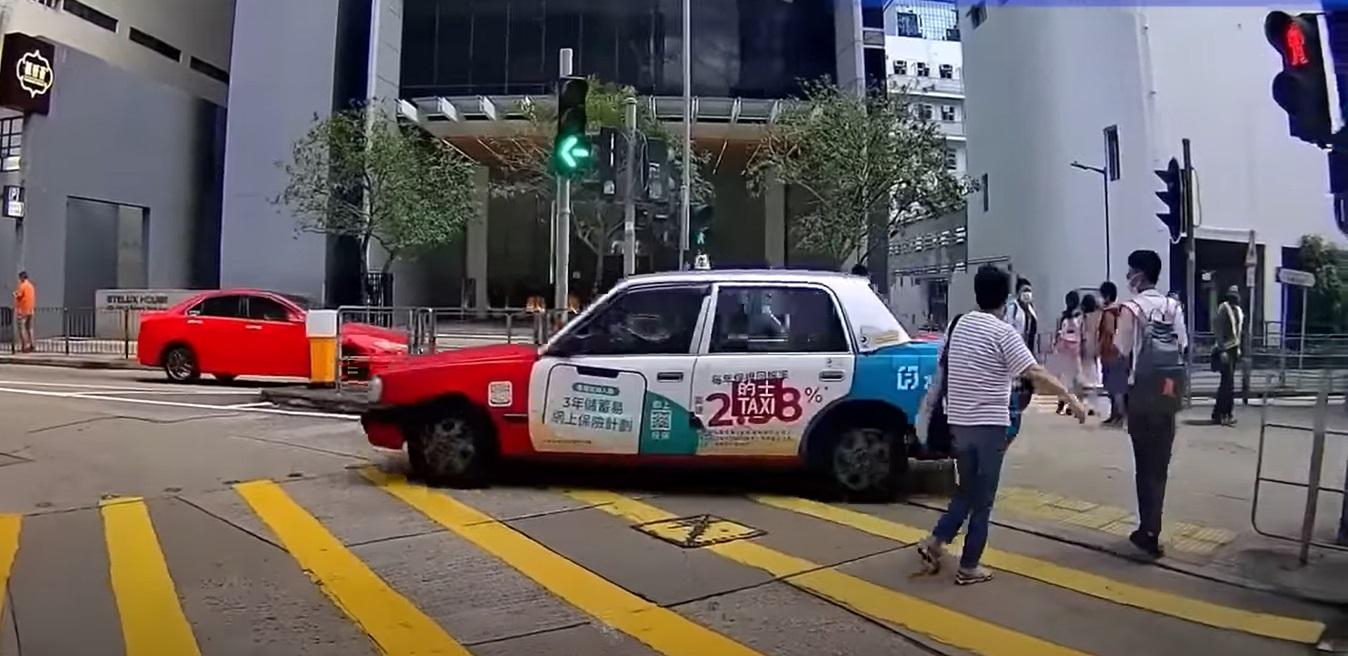 奪命的士走捷徑剷上安全島,與路人擦身而過。(影片截圖)