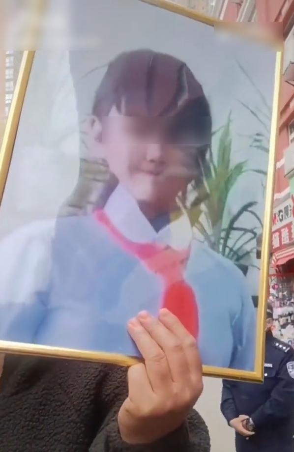 民眾在涉事文具店外舉起女童遺照。(互聯網)