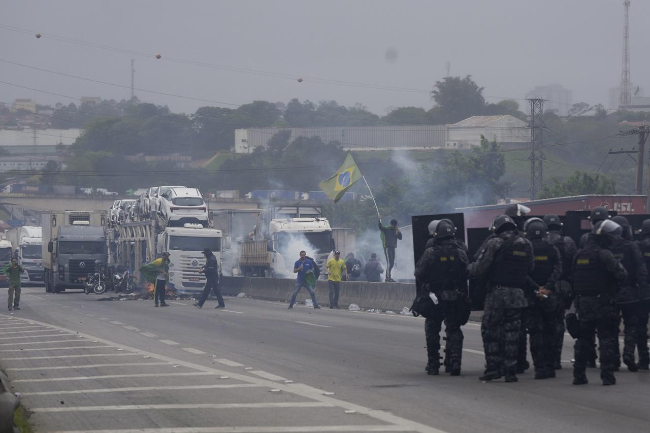 示威者設路障和燒車胎等雜物。警員向多輛罷駛堵路貨車和示威者施放催淚氣體。(AP)