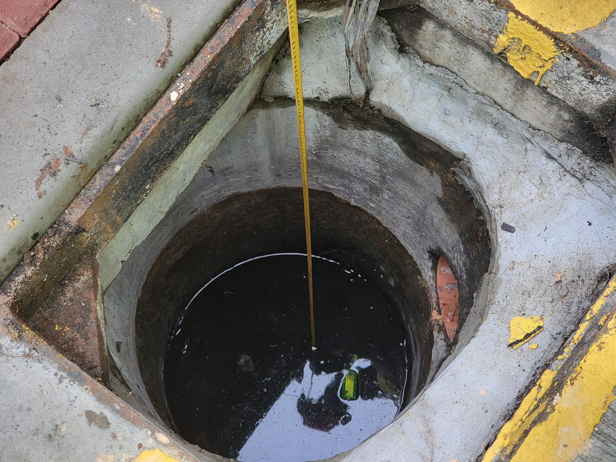 警員其後以工具抽走坑渠內積水,尋回相信屬於死者的銀包。(鍾式明攝)