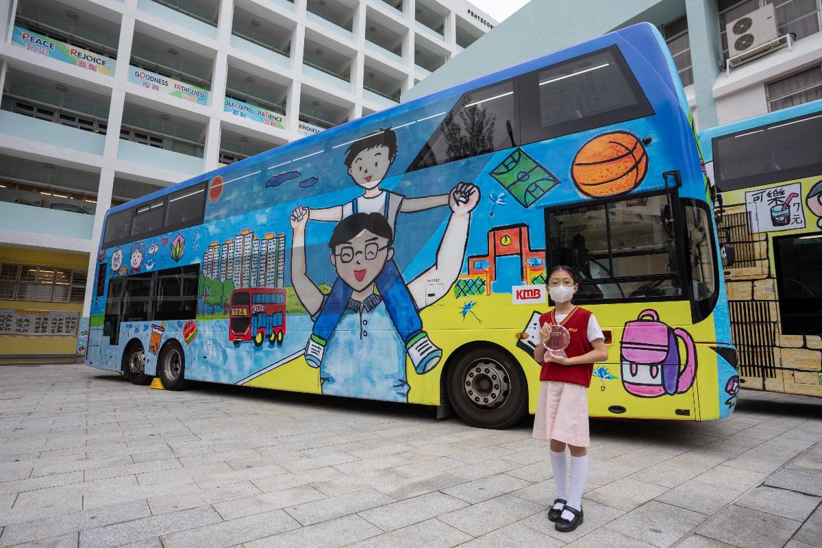 季軍得主五旬節于良發小學學生蘇宇芊與相應的巴士合照。(九巴提供)