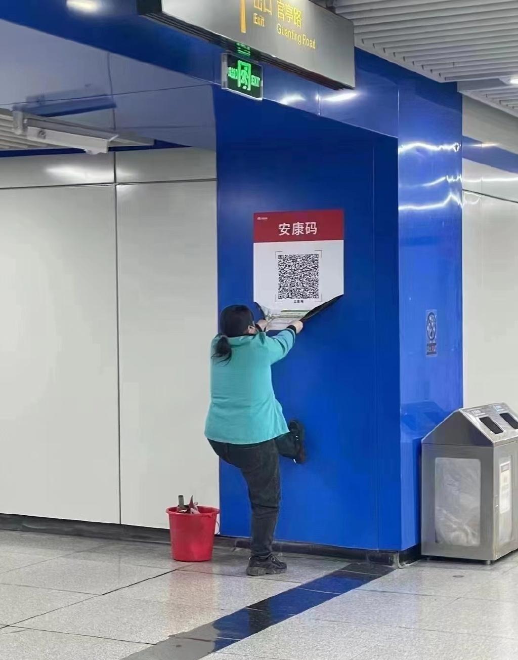 安徽合肥地鐵工作人員清除健康碼掃碼海報。(互聯網)
