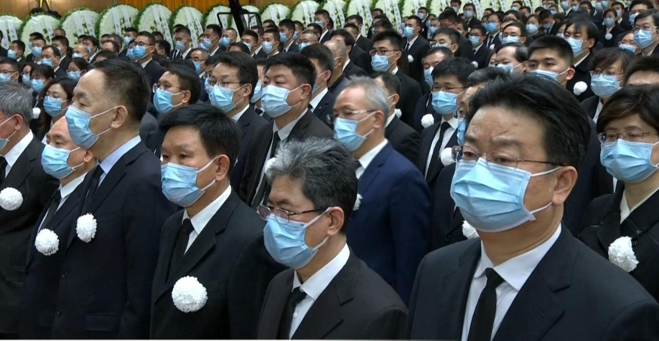 出席者都在衣服上佩上白花。