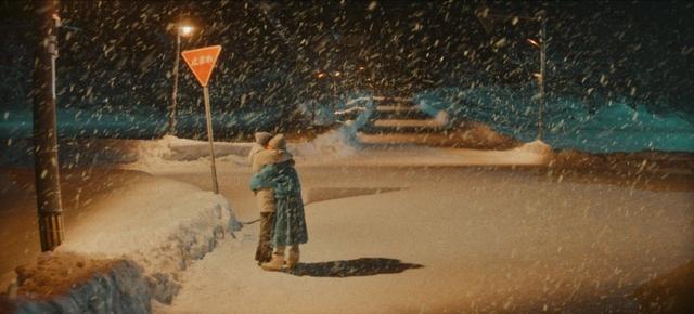 男女主角在白雪紛飛的夜景下擁吻,畫面非常唯美。