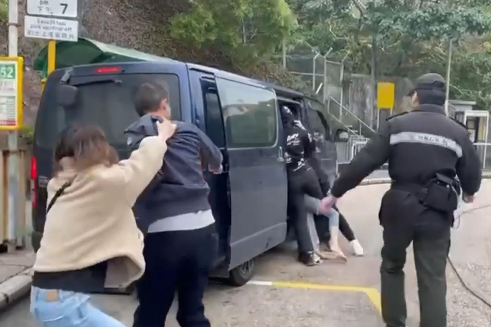 赤柱監獄外周六有人被擄走,一名女子被多人抬上客貨車,市民和懲教署人員制止不果。(網上片段截圖)