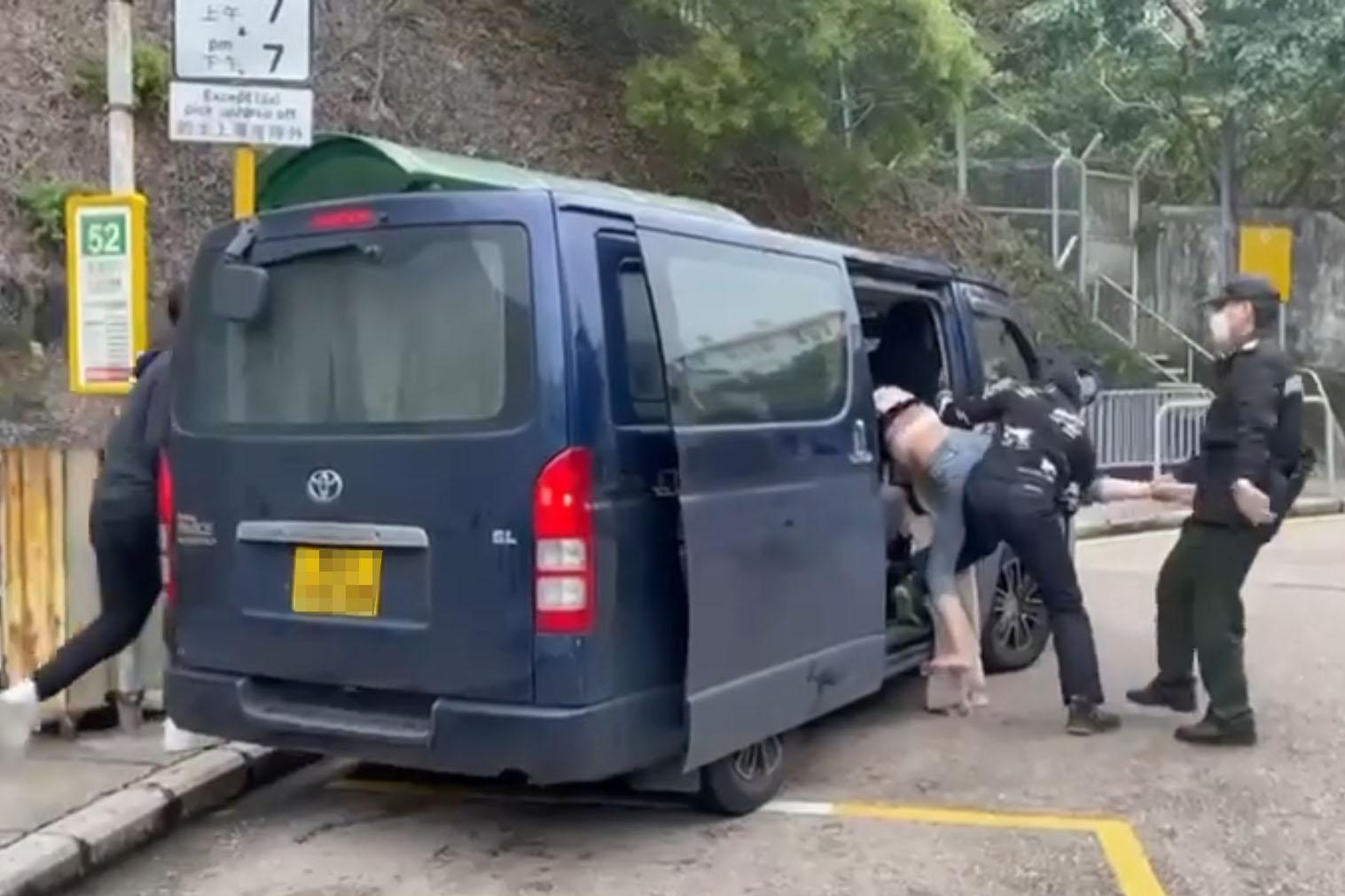 赤柱監獄外周六有人被擄走,一名女子被多人抬上客貨車,市民和懲教署人員制止不果。(網上片段截圖)