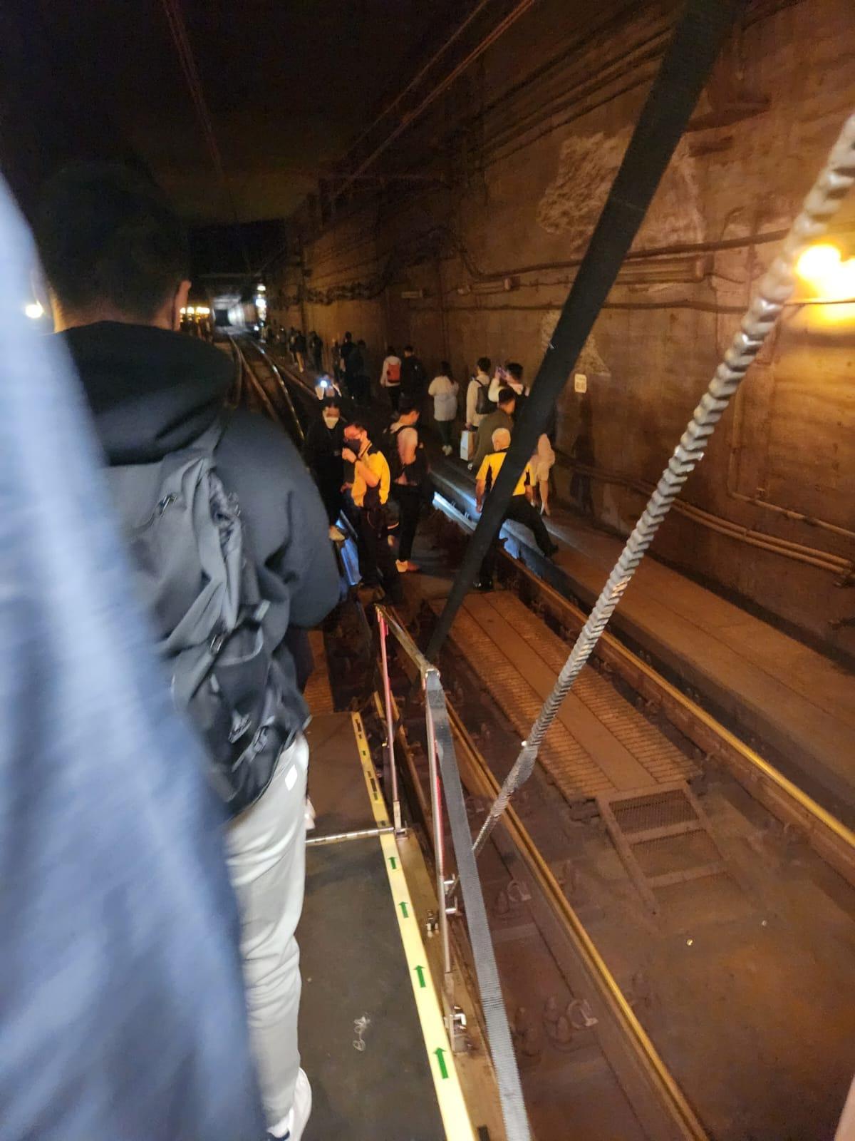 車廂燈光熄滅乘客沿路軌旁返回月台