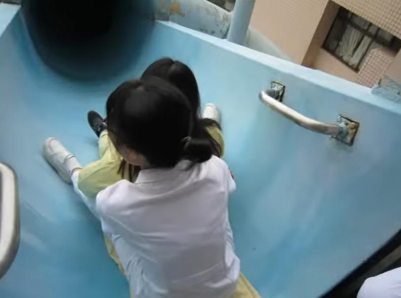 病人由醫護人員抱著滑下逃生滑梯。(影片截圖)